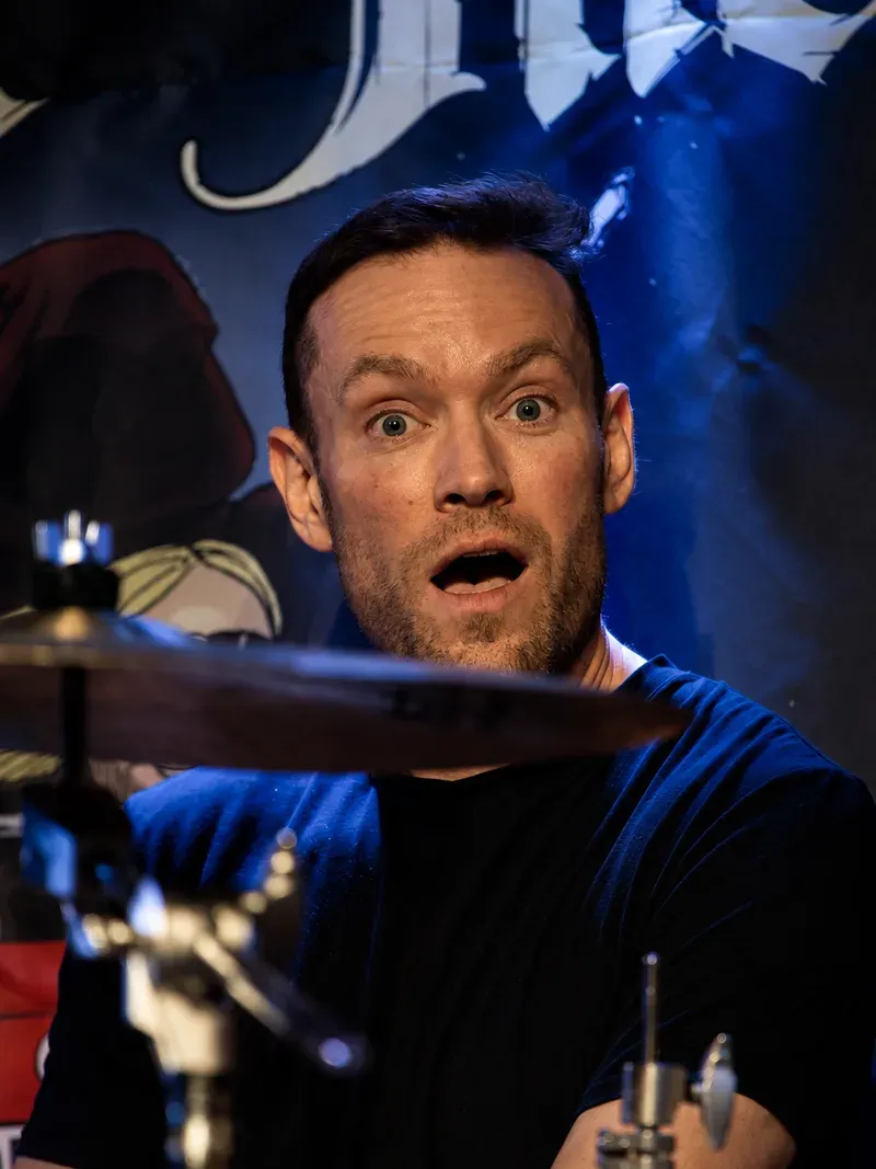 Stian Rekdal bak trommesettet, med Nerli There-backdropen bak seg