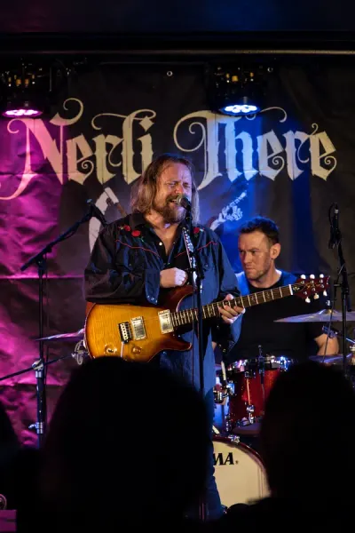 Nerli There på scenen — Mats Nerli, med bandnavnet i bakgrunnen